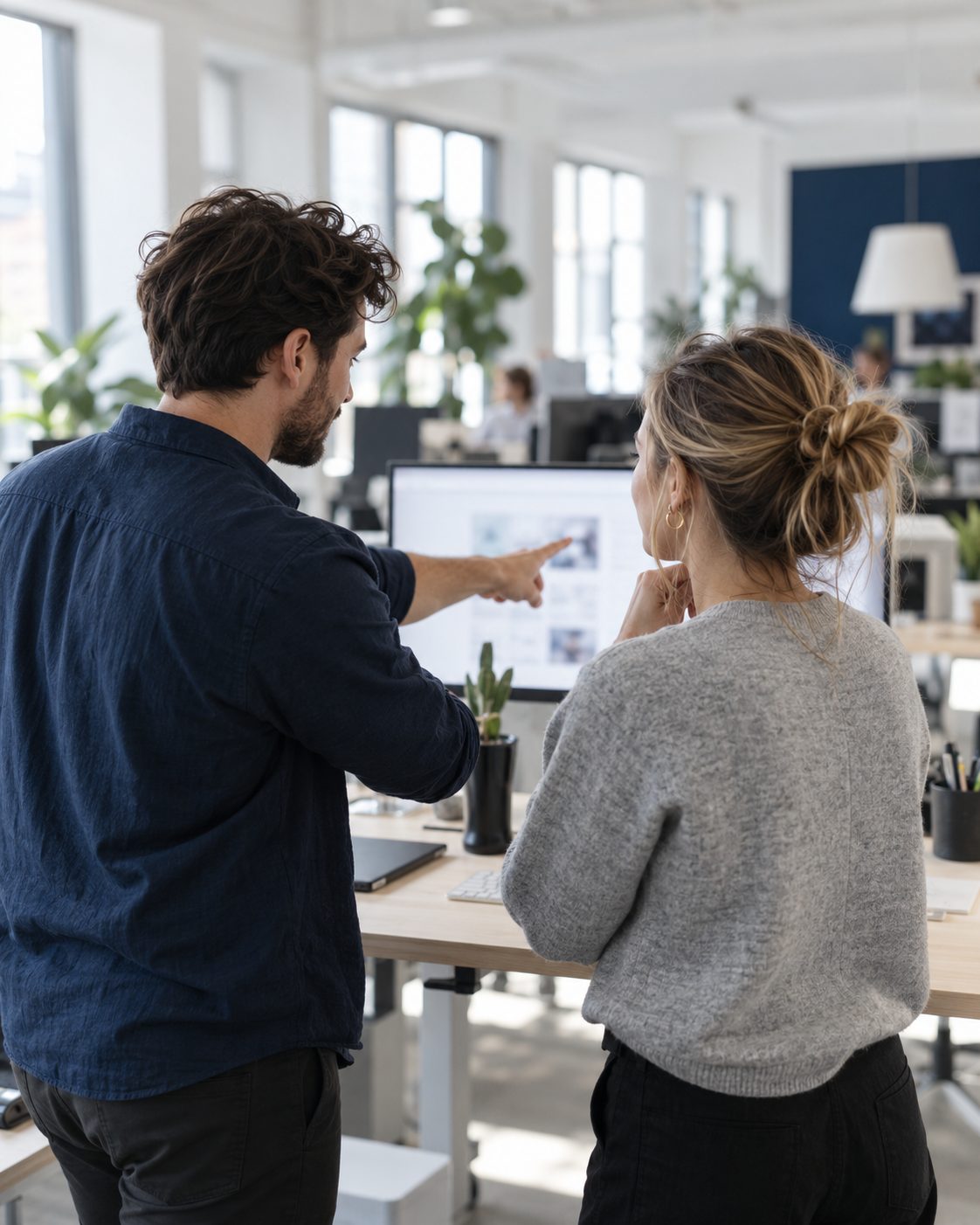 Two colleagues at a job board company reviewing results together at a standing desk